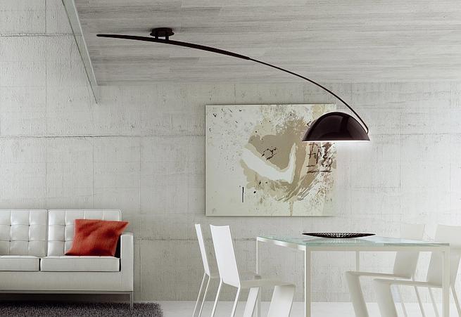 Lampy sufitowe i beton w salonie z jadalnią. Minimalistyczny salon
